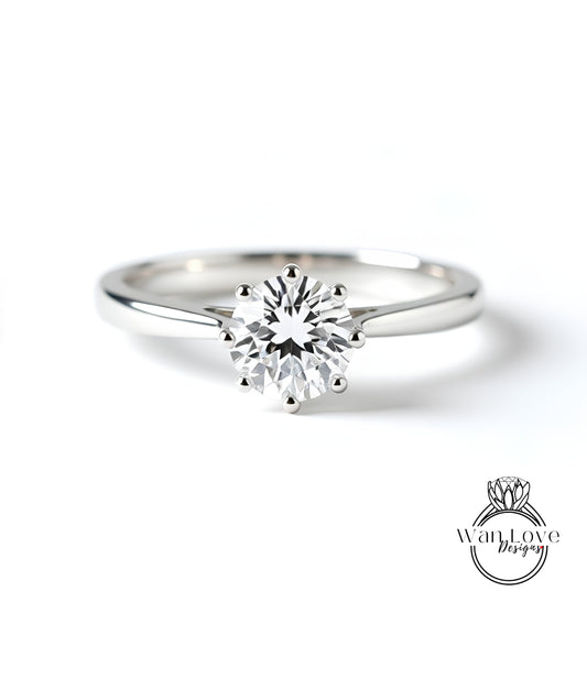 A close-up of a diamond engagement ring with a large central diamond surrounded by smaller diamonds.