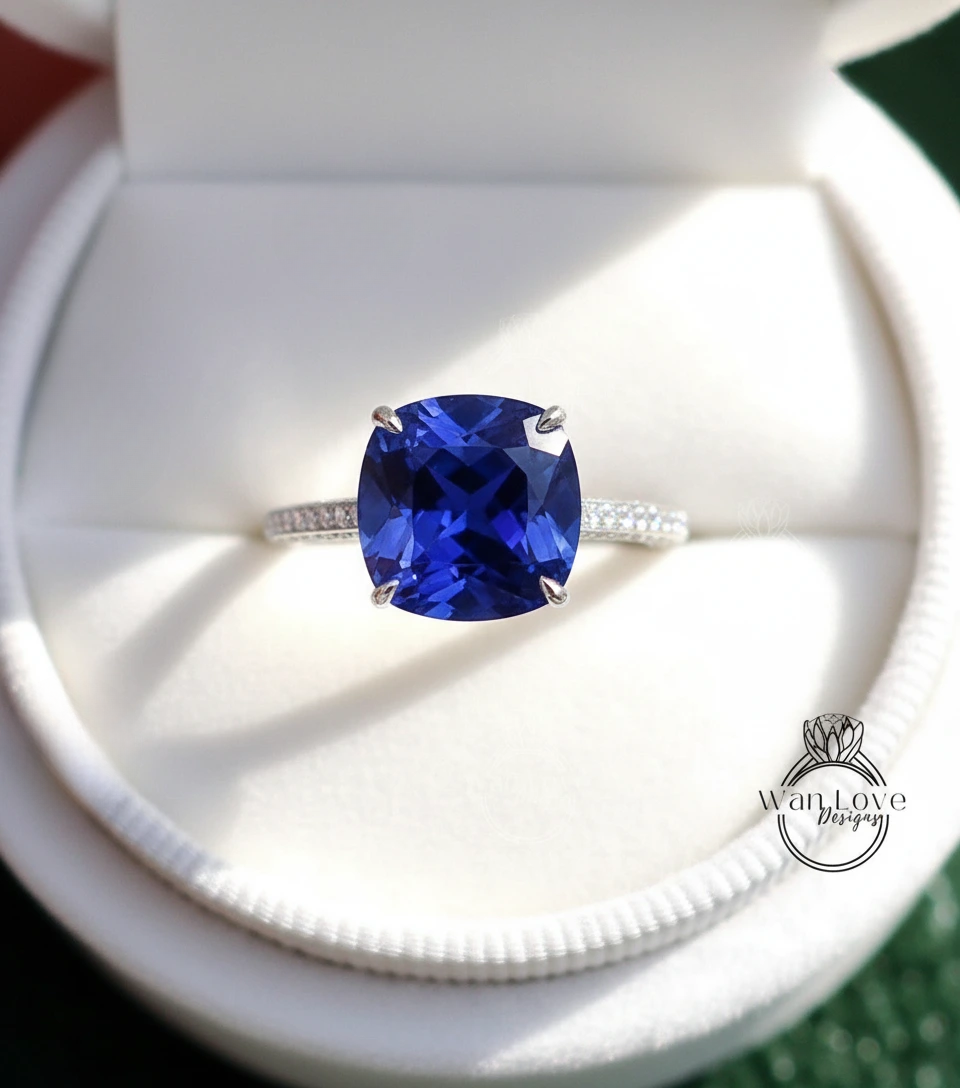 A close-up view of a diamond engagement ring with a large blue gemstone set in a silver band.