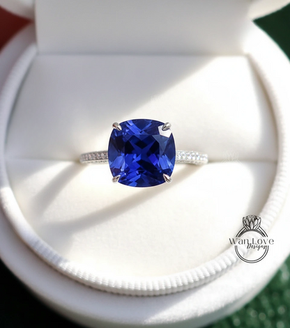 A close-up view of a diamond engagement ring with a large blue gemstone set in a silver band.