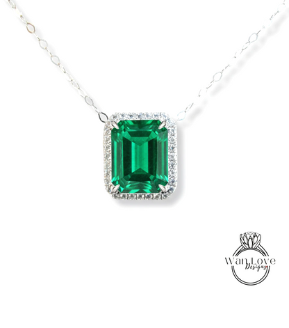 A necklace with a large, square-cut emerald gemstone surrounded by a halo of smaller diamonds.