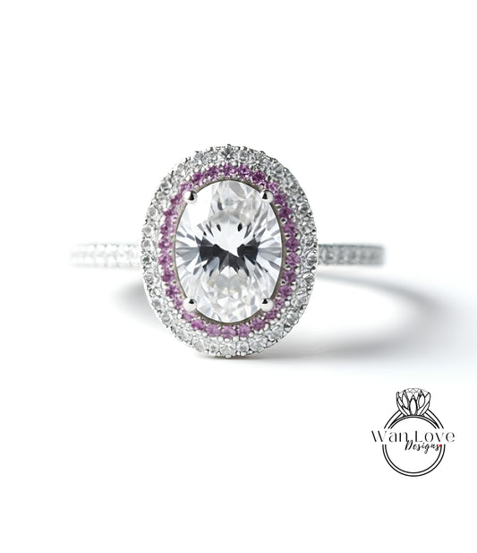 A close-up of a diamond ring with a large oval-shaped diamond surrounded by a halo of smaller diamonds and colored gemstones.
