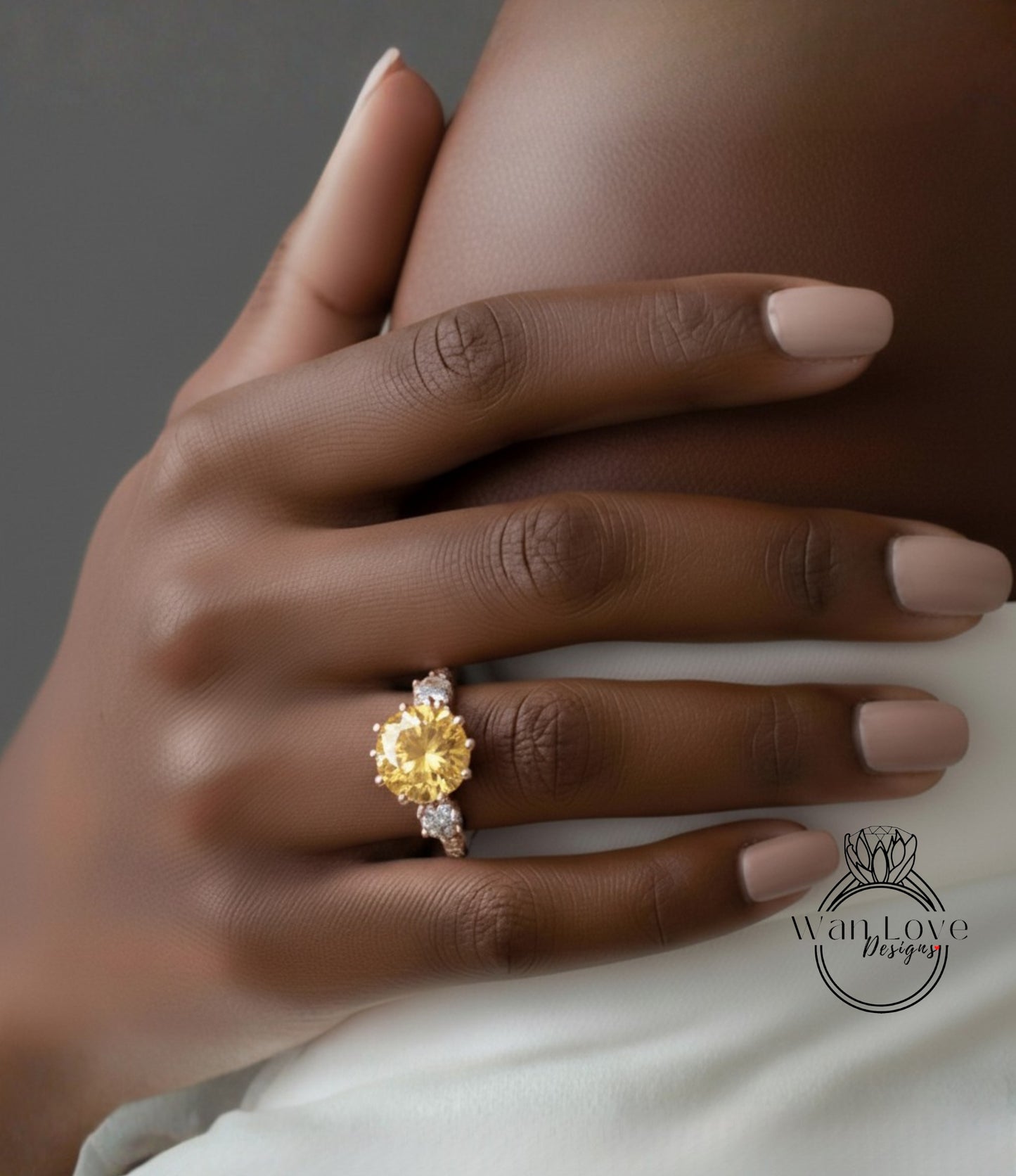 A close-up of a hand wearing a yellow diamond ring on the ring finger.