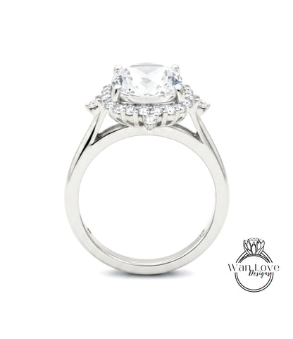 A close-up view of a silver engagement ring with a large central diamond surrounded by smaller diamonds.