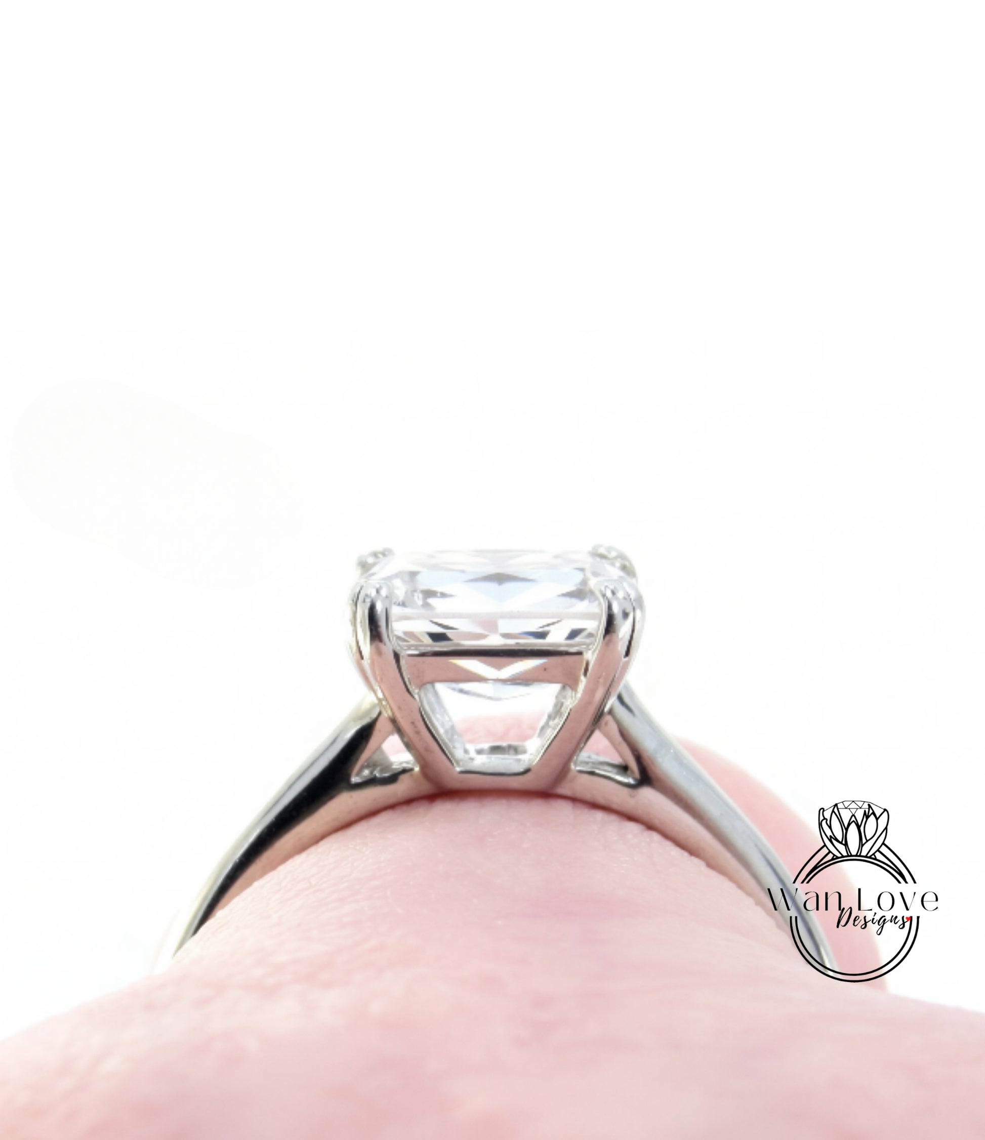 A close-up view of a diamond engagement ring on a person's hand.
