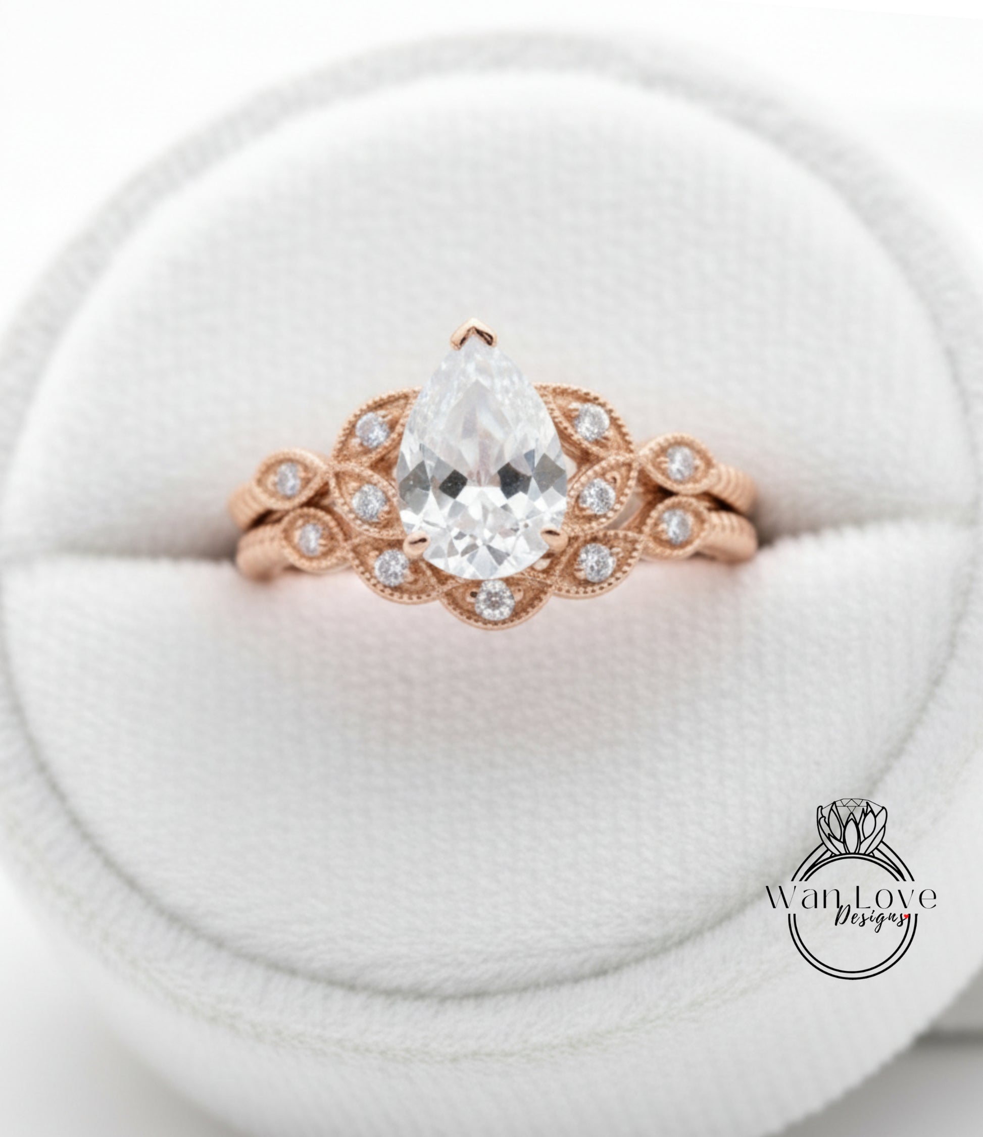 A close-up image of a gold ring with a large pear-shaped diamond set in the center, surrounded by smaller diamonds.