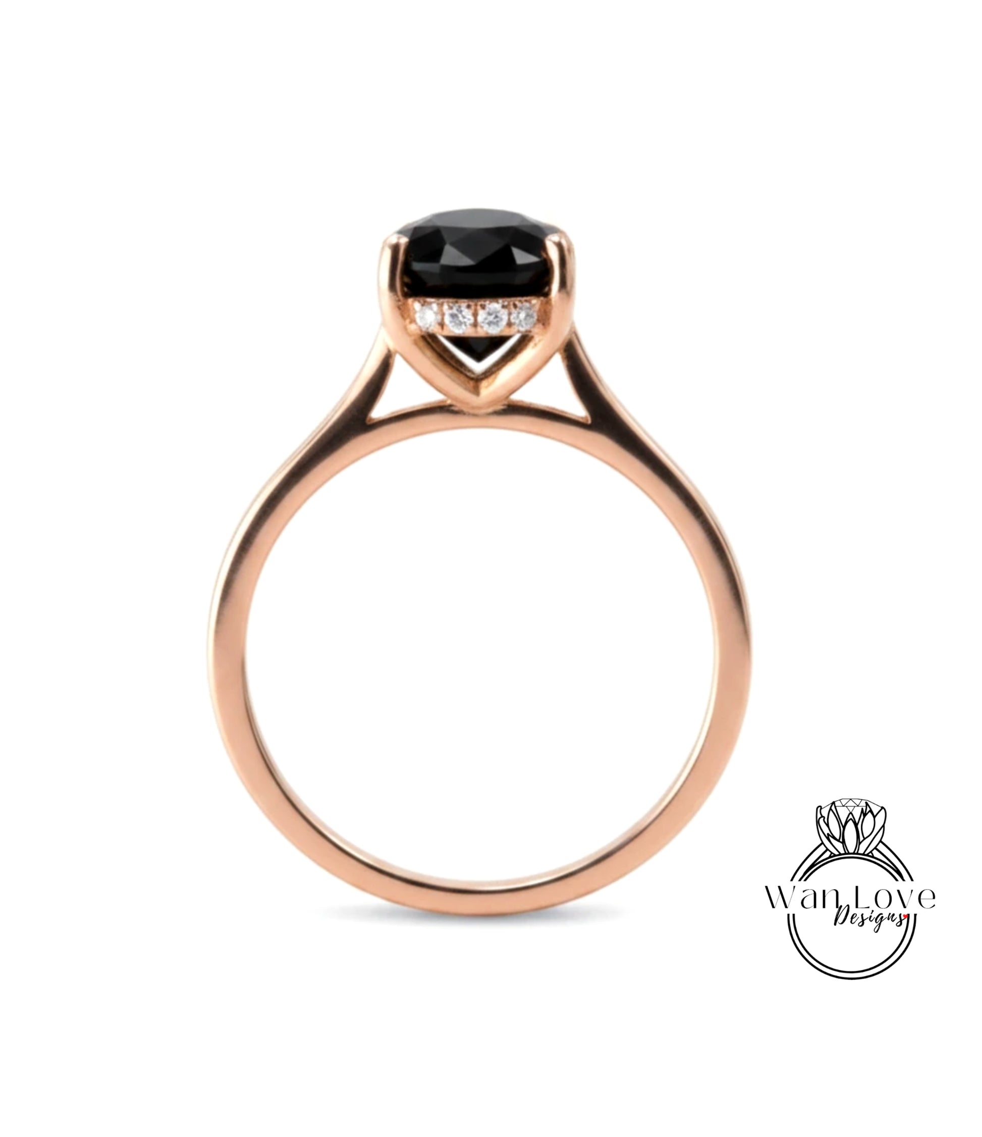 A rose gold engagement ring with a large black gemstone set in the center.
