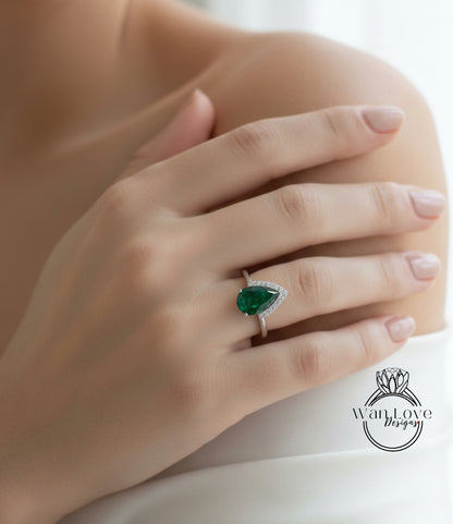 A close-up of a person's hand wearing a ring with a large, vibrant green gemstone.