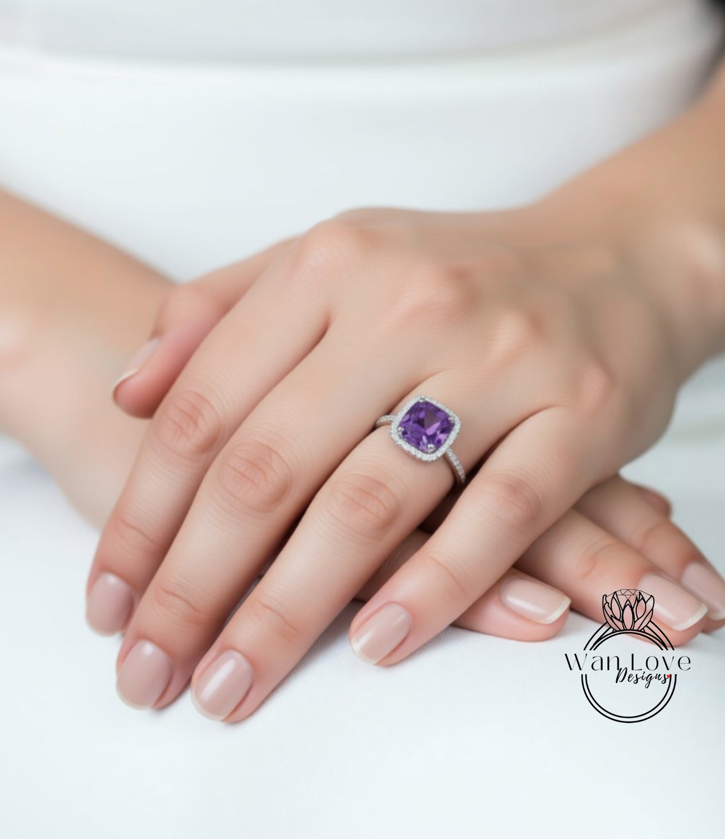 A close-up image of a person's hand wearing a ring with a purple gemstone.