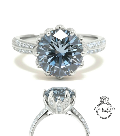 A stunning blue diamond engagement ring with a large central diamond surrounded by smaller diamonds on either side, set in a silver band.