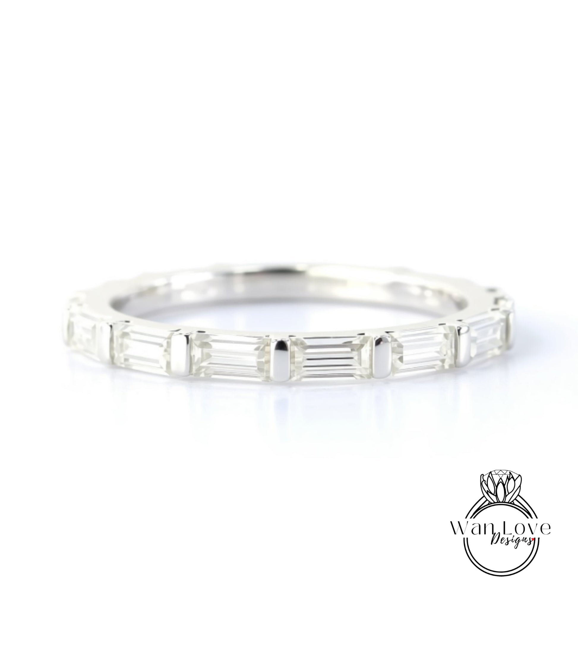 A silver band ring with a row of clear gemstones, likely diamonds, set in a simple and elegant design.