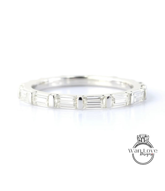 A silver band ring with a row of clear gemstones, likely diamonds, set in a simple and elegant design.