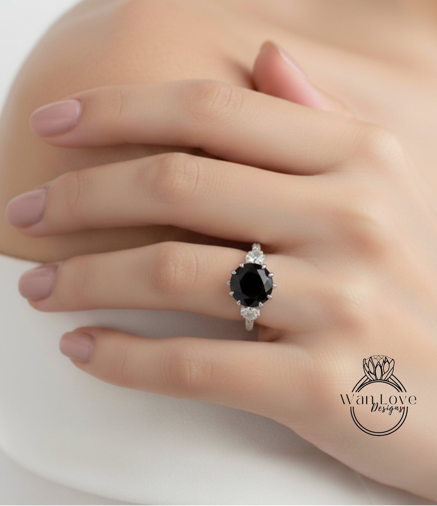 A close-up of a person's hand wearing a ring with a large black gemstone.