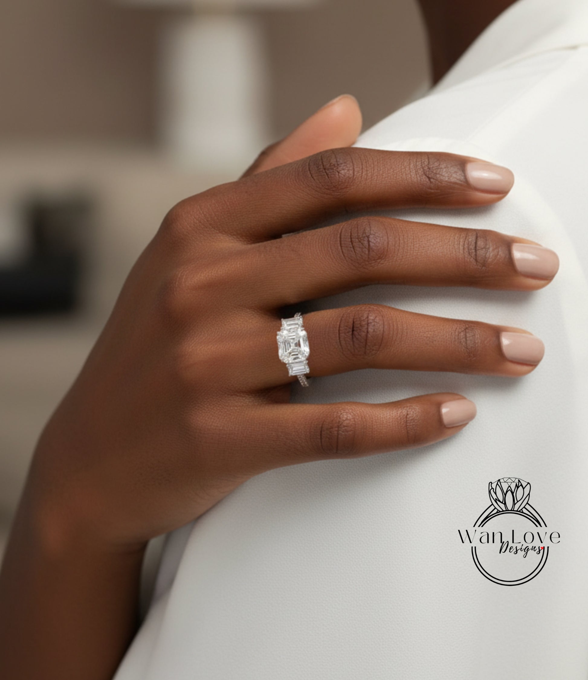 A close-up of a person's hand wearing a diamond engagement ring on the ring finger.