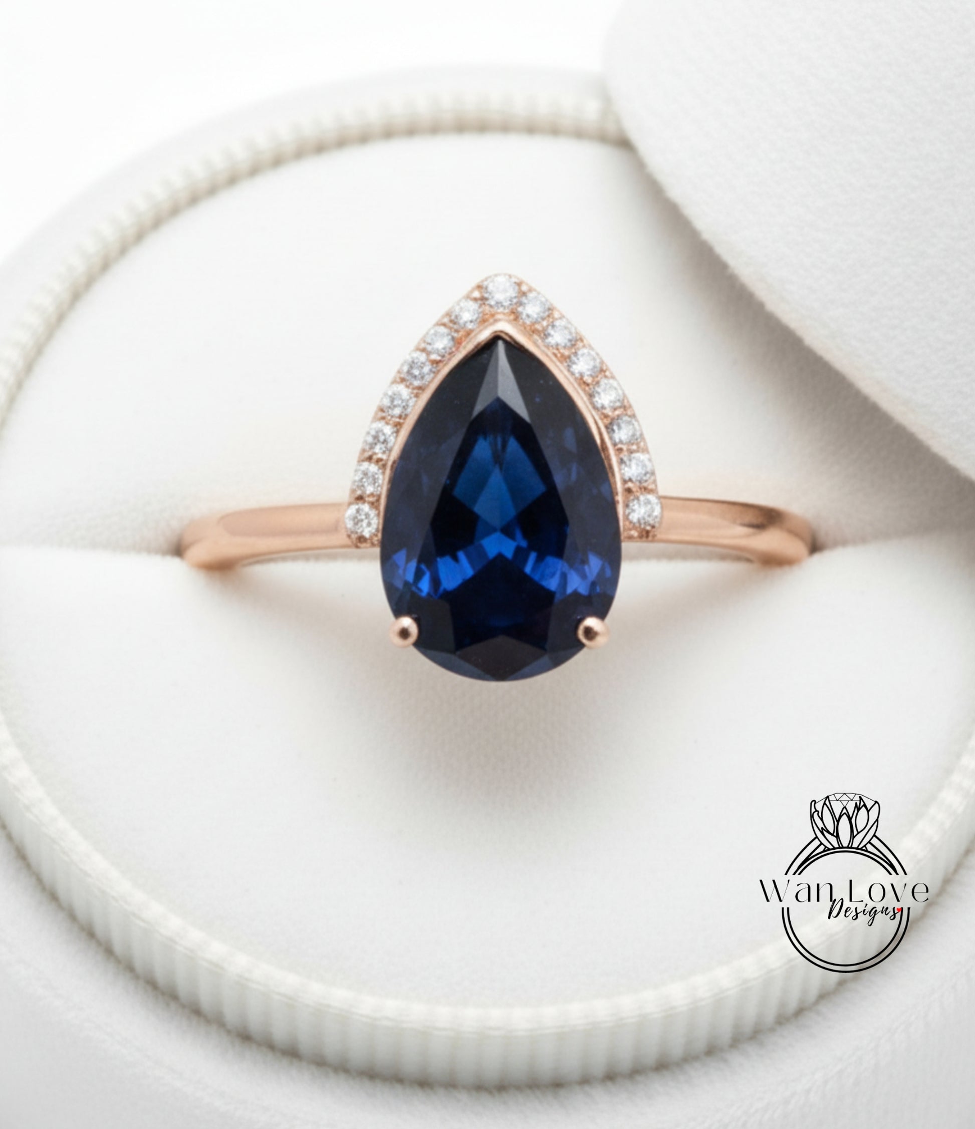 A close-up image of a gold ring with a large blue gemstone, placed in a white box.