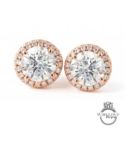 A pair of elegant earrings with large, clear diamonds set in a halo of smaller diamonds, all encircled by a thin gold band.