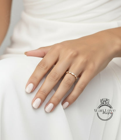A close-up of a hand wearing a gold ring with a row of diamonds on the ring band.