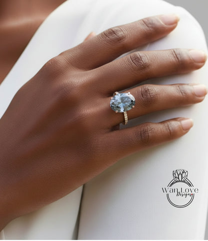 A close-up of a person's hand wearing a large, blue gemstone ring on the ring finger.