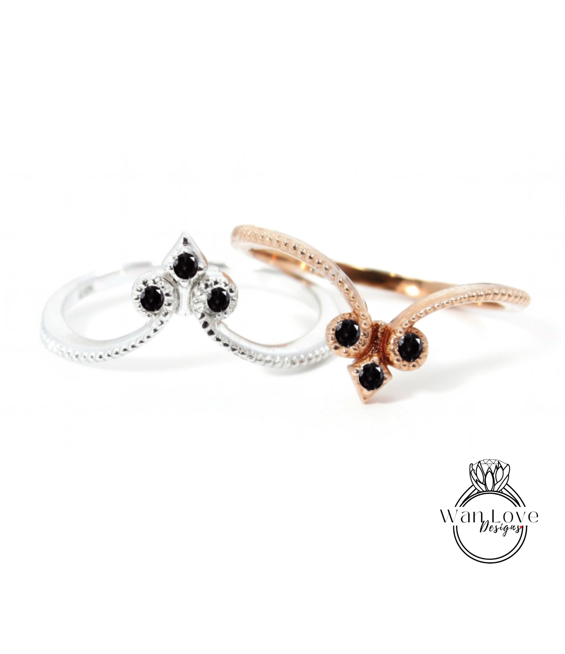 two rings with black gemstones, one silver and one gold, against a white background.