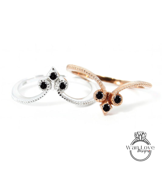 two rings with black gemstones, one silver and one gold, against a white background.