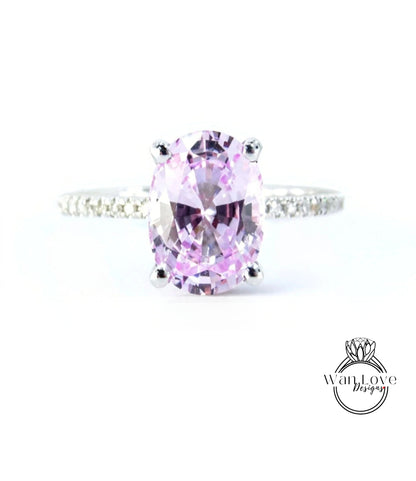 A close-up image of a ring featuring a large oval-shaped purple gemstone, likely a sapphire, set in a silver band.