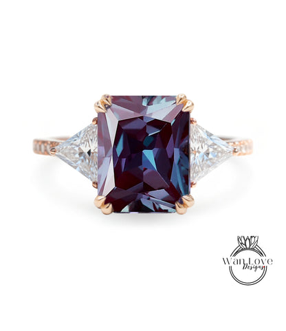 A large, purple gemstone ring with a gold band and two smaller diamonds on either side.