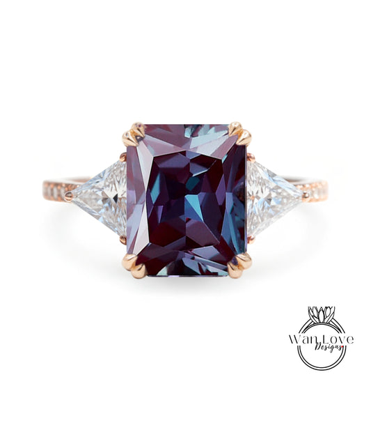 A large, purple gemstone ring with a gold band and two smaller diamonds on either side.