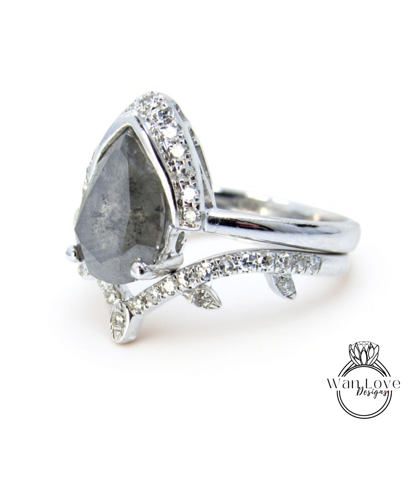 A silver ring with a large diamond as the centerpiece, surrounded by smaller diamonds and a leaf-shaped accent.