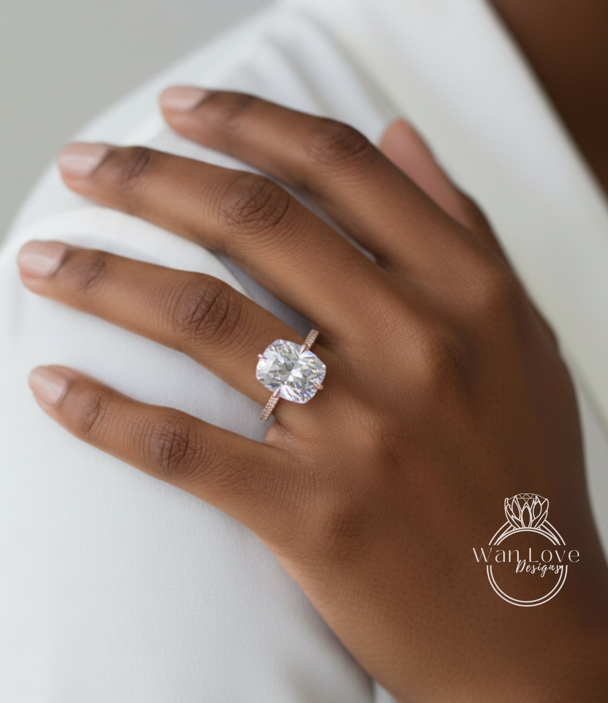 A close-up of a person's hand wearing a large, clear diamond engagement ring on the ring finger.