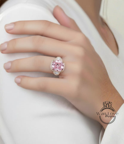 A close-up of a person's hand wearing a large, ornate ring with a pink gemstone.