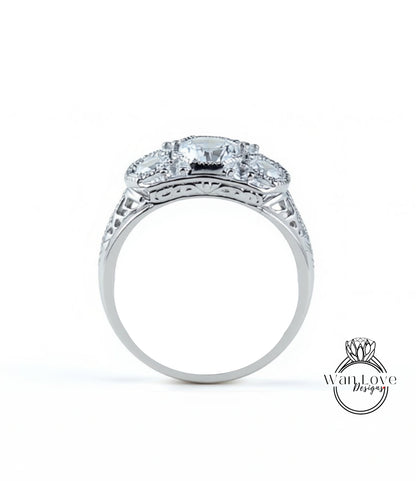 A silver ring with a large central diamond surrounded by smaller diamonds, showcasing intricate metalwork and detailing.