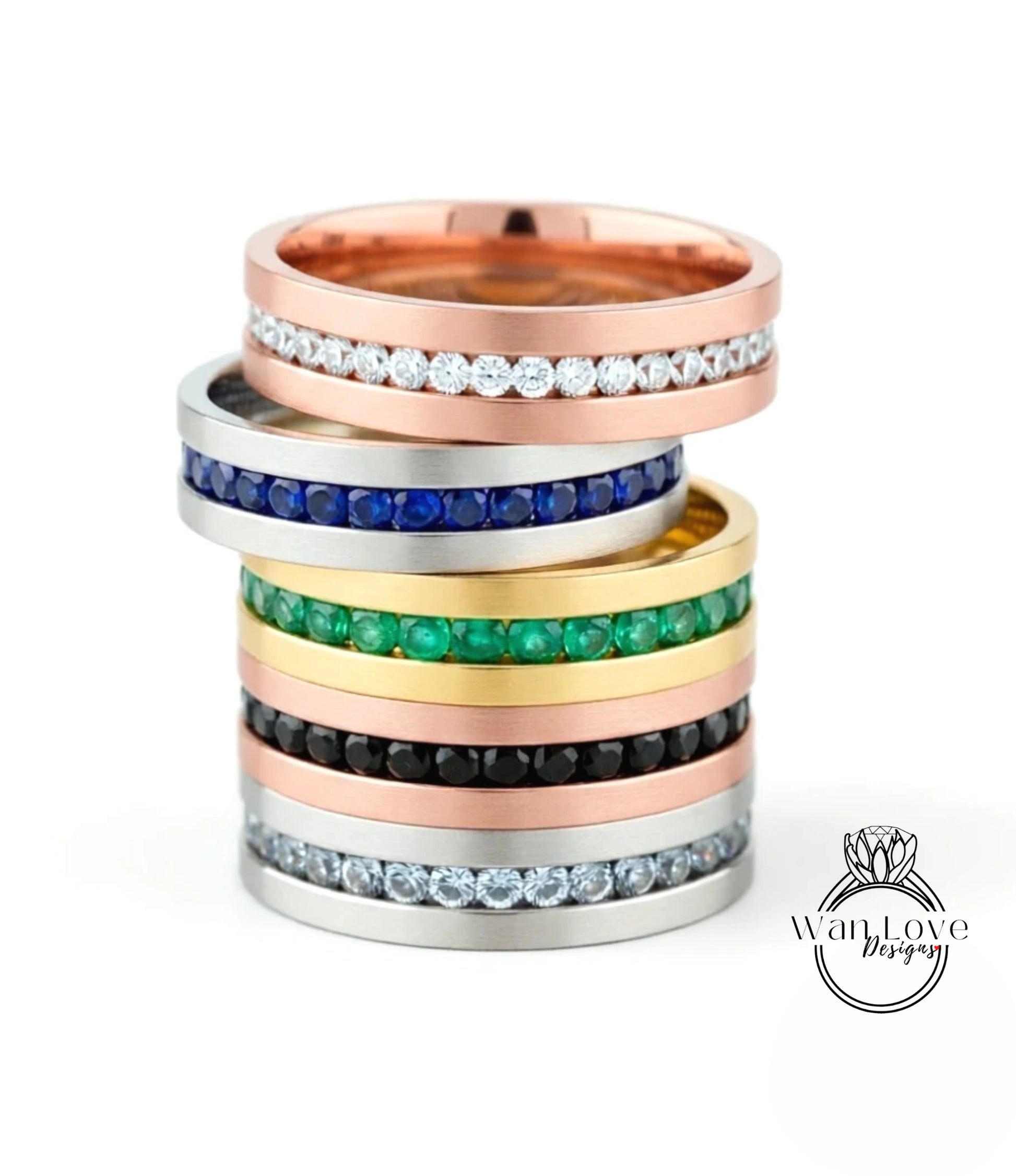 A stack of rings with various colored gemstones set in them, including diamonds and colored stones.