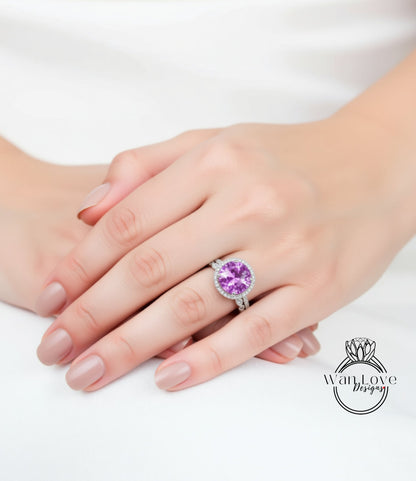 A close-up image of a person's hand wearing a large, round, purple gemstone ring.