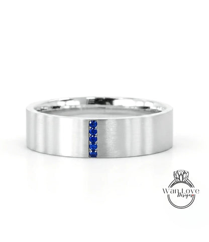 A silver-colored ring with a blue gemstone in the center, set against a white background.