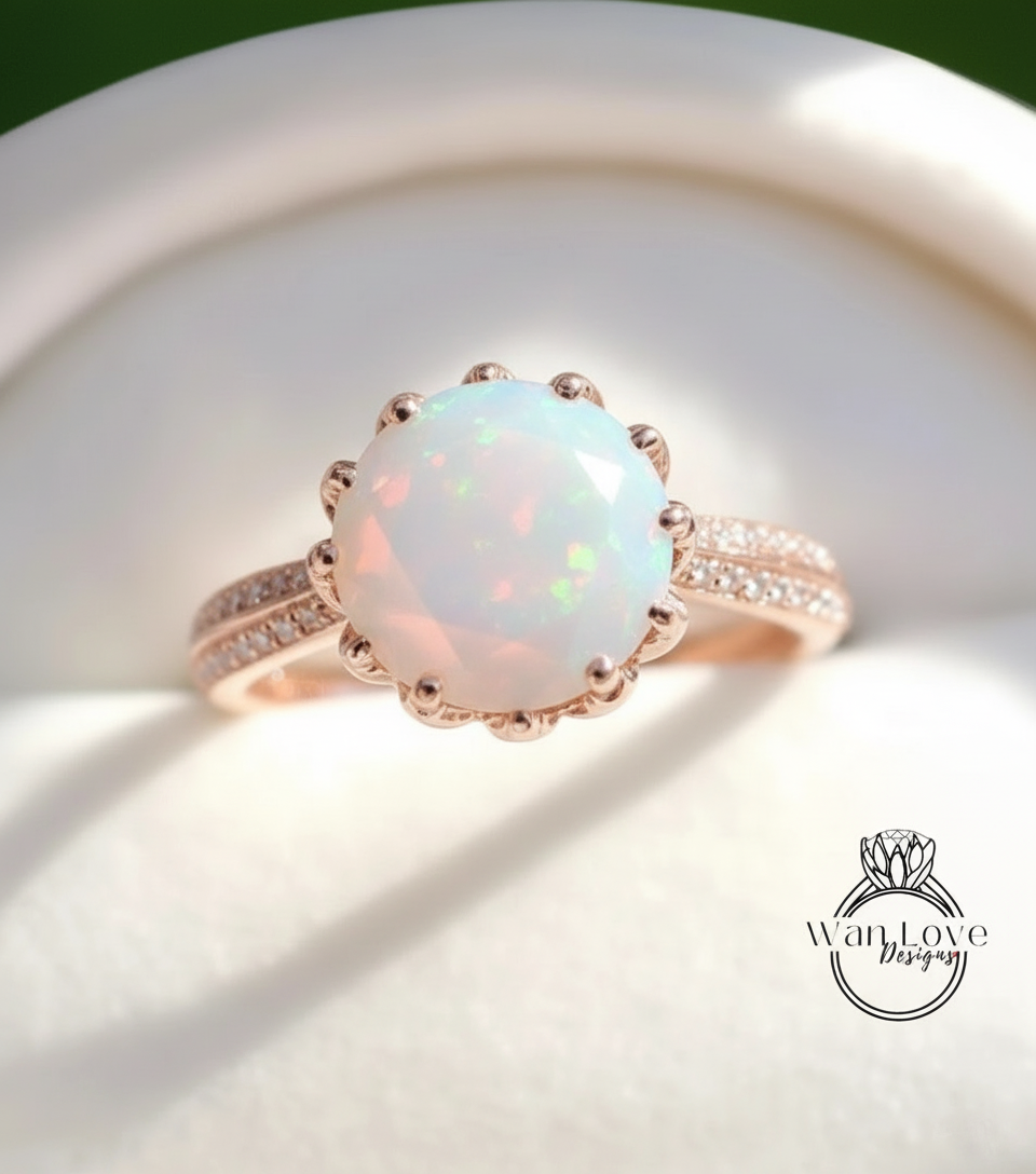 A close-up image of a gold ring with a large, round opal gemstone set in the center, surrounded by smaller diamonds.