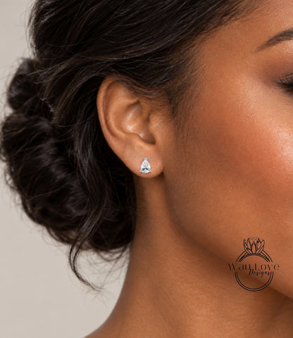 A close-up of a woman's ear with a diamond earring, featuring a small, clear gemstone.