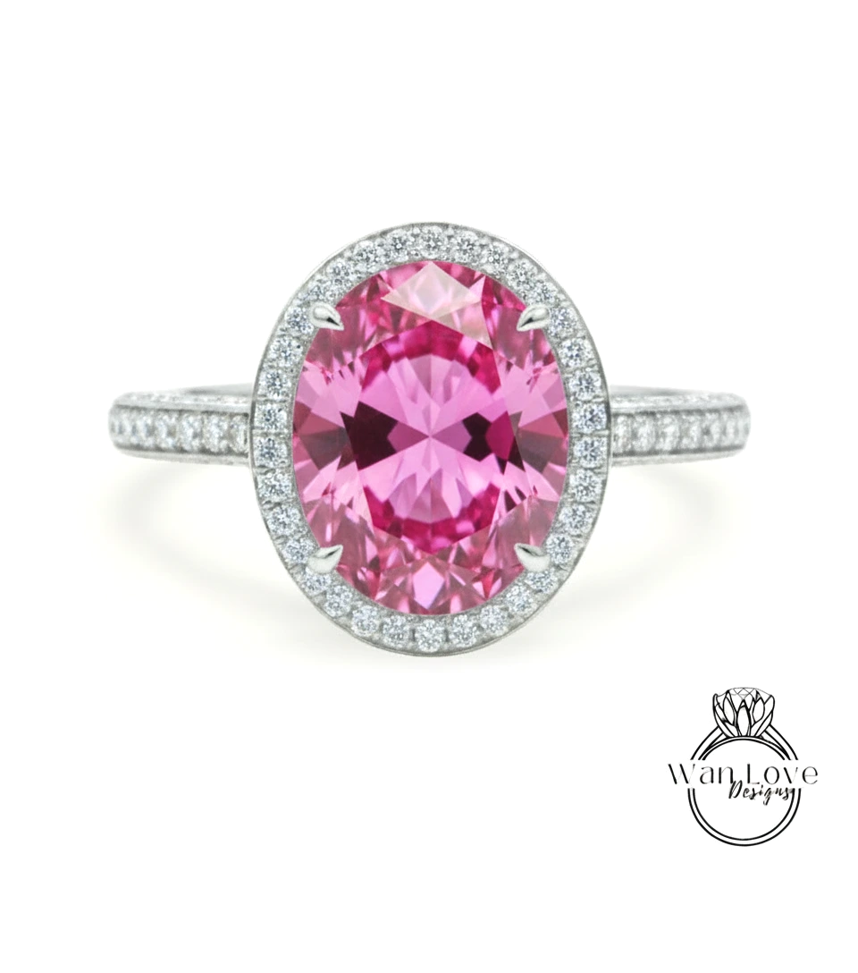 A pink gemstone ring with a halo of diamonds around the center stone.