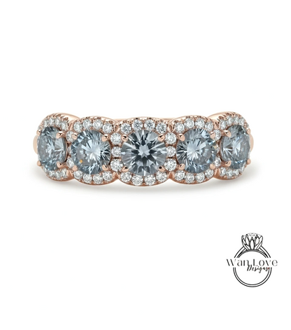 A rose gold ring with a halo of small diamonds around the center stone.