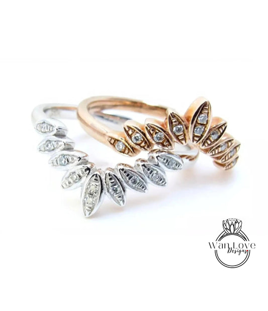 two rings with intricate designs, including a silver ring with a large central diamond and a gold ring with a smaller central diamond.