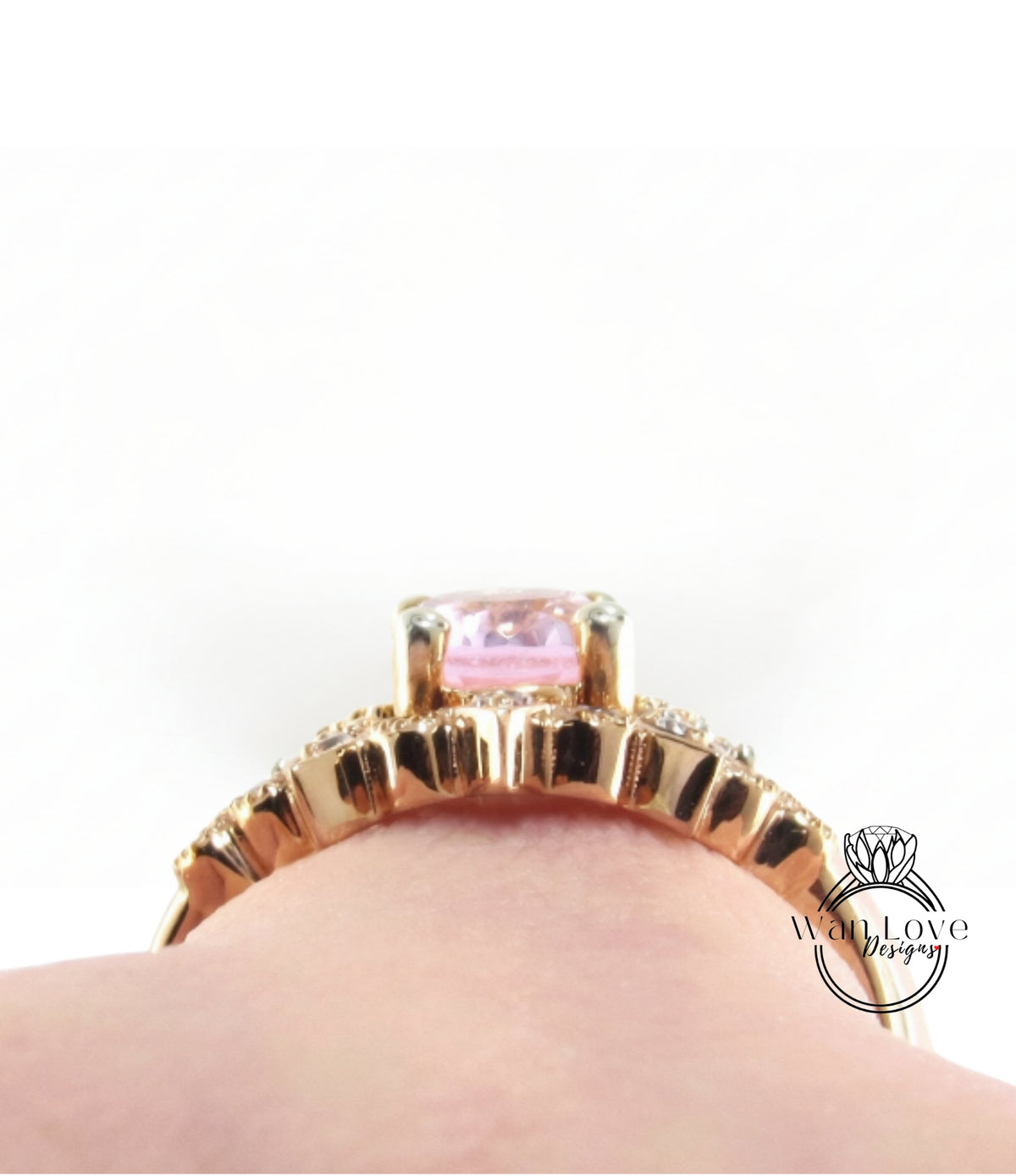 A close-up view of a gold ring with a pink gemstone, showcasing the intricate design and details of the jewelry piece.