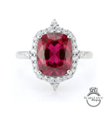 A stunning ring featuring a large, deep red gemstone surrounded by a halo of smaller diamonds, set in a silver band.
