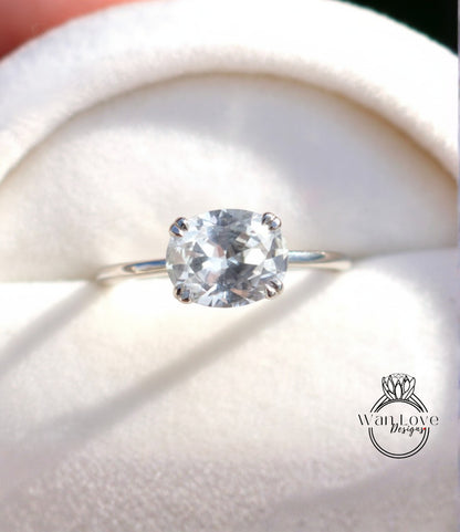A close-up view of a diamond engagement ring with a large, clear gemstone set in a silver band.