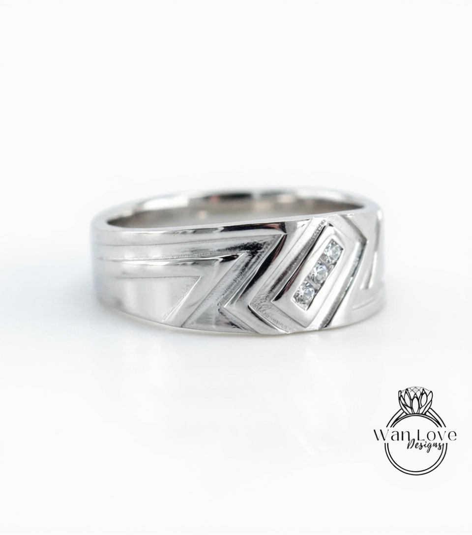 A silver ring with a geometric design and a small diamond set in the center.