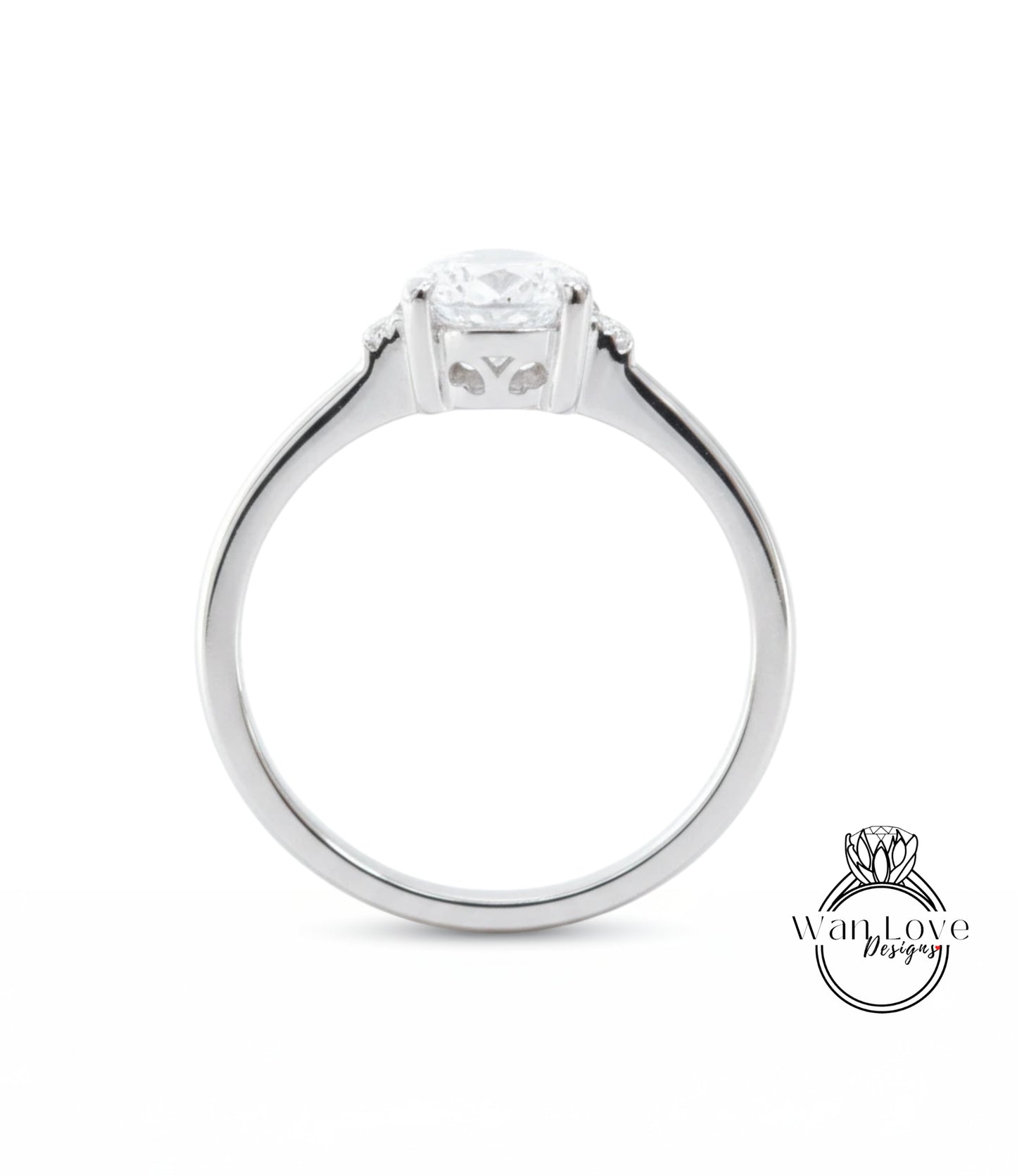 A silver engagement ring with a large central diamond and a smaller diamond on either side.