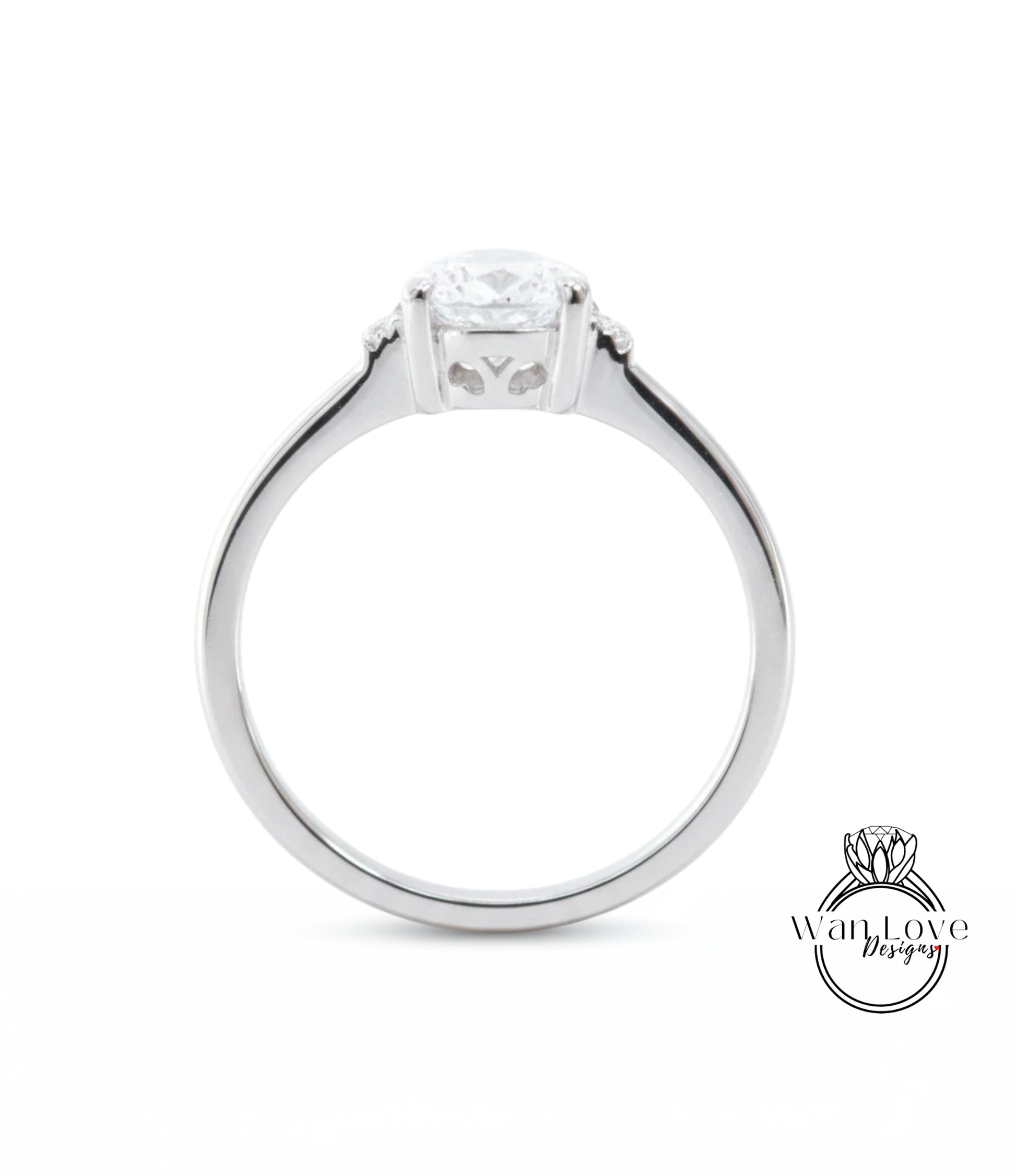 A silver engagement ring with a large central diamond and a smaller diamond on either side.