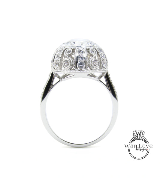 A silver ring with a large, round diamond at the center, surrounded by intricate designs.