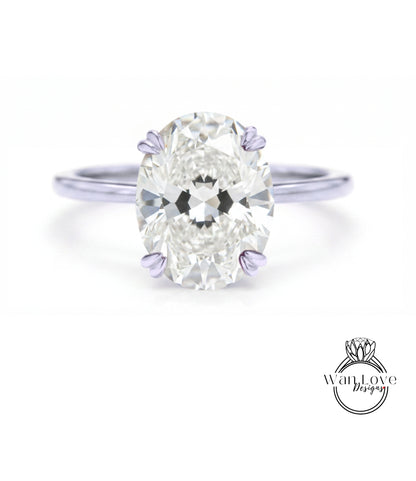 A close-up of a diamond engagement ring with a large oval-shaped diamond set in a silver band.