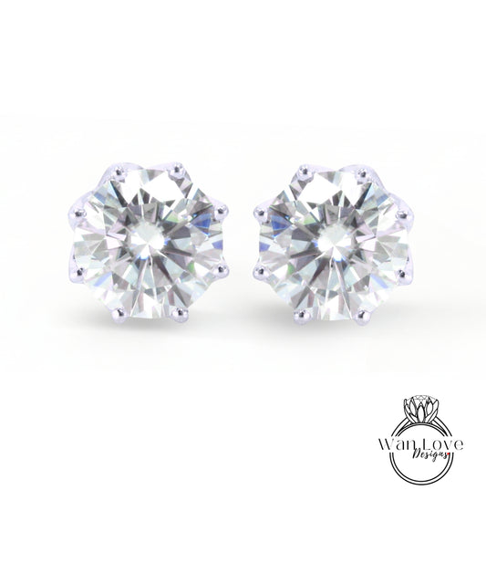 A pair of elegant earrings featuring a large, brilliant-cut diamond set in a silver-colored metal.