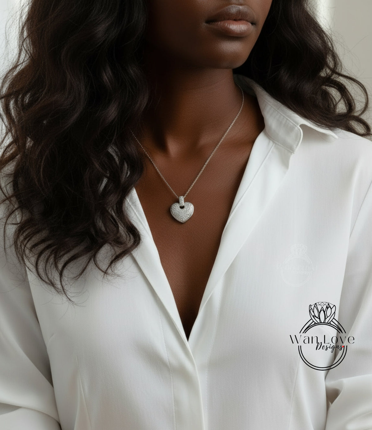 A close-up of a woman wearing a white blouse and a necklace with a heart-shaped pendant.