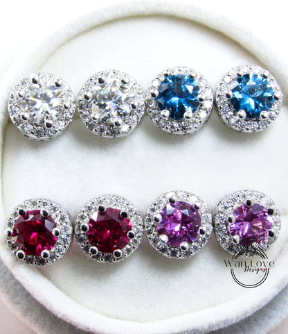 A pair of earrings with various colored gemstones, including clear, blue, red, and purple stones, set in a silver and white design.