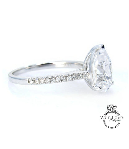 A close-up view of a diamond engagement ring with a large central diamond and a row of smaller diamonds along the band.